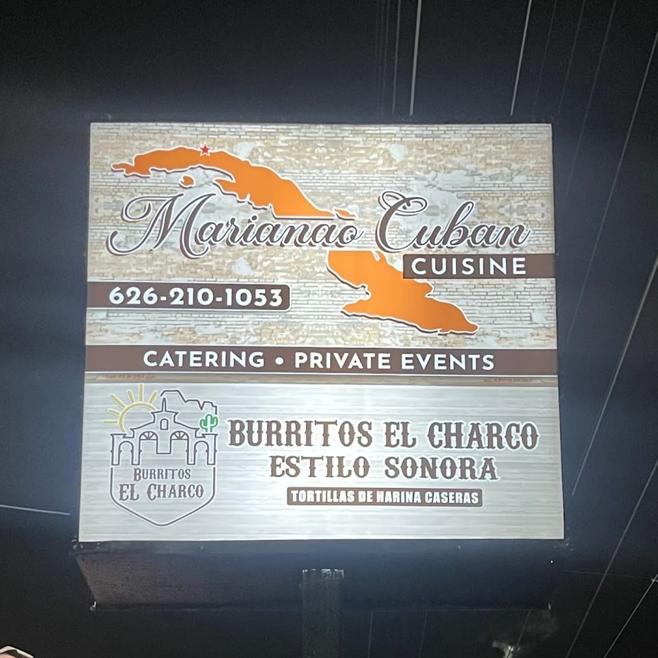 A lighted sign for Marianao Cuban Cuisine and Burritos El Charco Estilo Sonora at night.